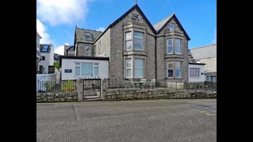 una casa grande con una valla delante en ABOVE PORTHMINSTER BEACH - "St James Rest" is a SUPER STYLISH PRIVATE APARTMENT - 2 mins walk Main Car Park & Station, en St Ives