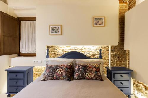 una camera con un letto con due comodini blu di Casa Deluxe Herreros ad Alcalá de Henares