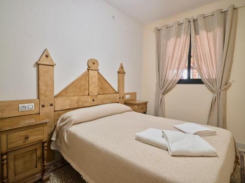 a bedroom with a bed and a dresser and a window at VILLA BASILIO in Constantina