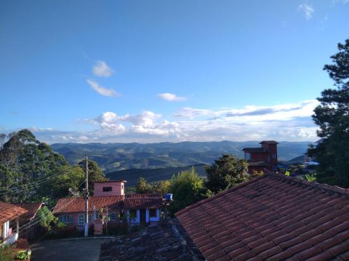 uma vista para uma aldeia com montanhas ao fundo em Chalé Suite do chá em Lavras Novas