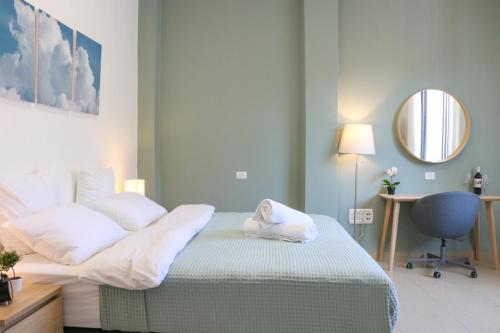 a bedroom with a bed with a mirror and a desk at Paris Square Apartments Downtown in Haifa