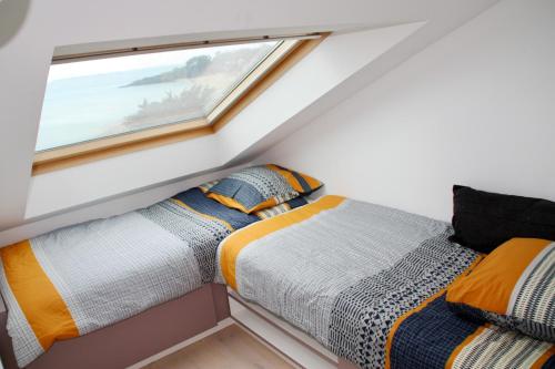 une chambre avec un lit et une fenêtre dans l'établissement Duplex face mer tout confort sur la plage /tennis, à Pornichet