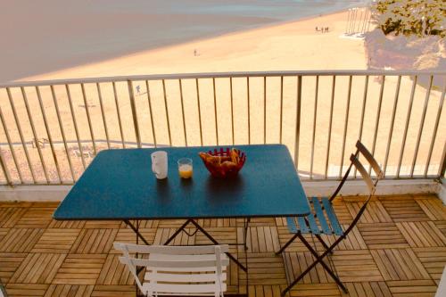 - une table sur un balcon avec vue sur la plage dans l'établissement Duplex face mer tout confort sur la plage /tennis, à Pornichet