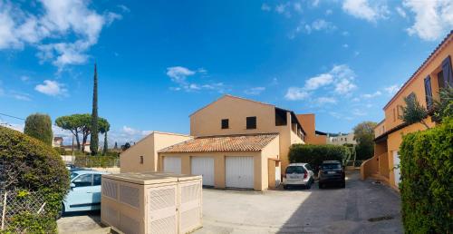a house with cars parked in a parking lot at Les Tamaris in Saint-Cyr-sur-Mer