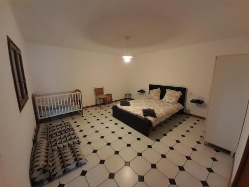 een slaapkamer met een bed en een tegelvloer bij Maison chaleureuse in Rustrel