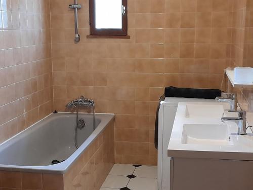 a bathroom with a tub and a sink at Maison chaleureuse in Rustrel