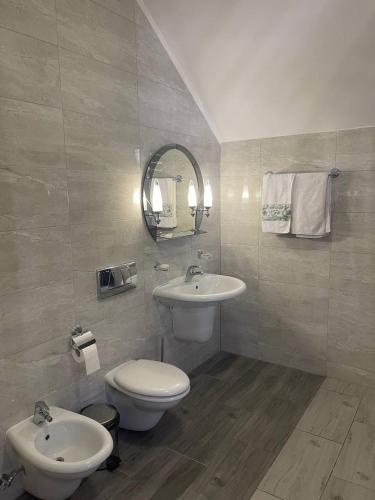 a bathroom with a sink and a toilet and a mirror at Зруб in Skhidnitsa