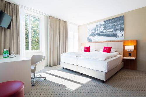 una habitación de hotel con una cama grande con almohadas rojas en Hotel Wartmann am Bahnhof, en Winterthur