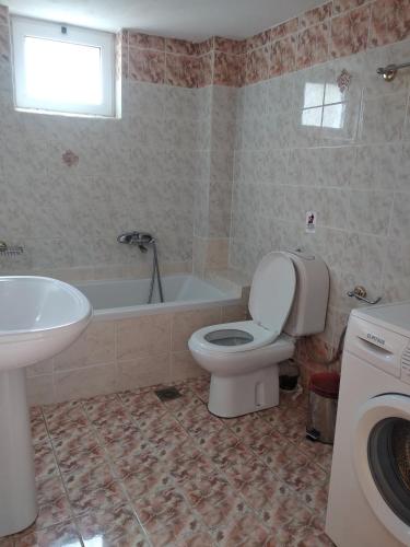 a bathroom with a toilet and a sink and a tub at Ton Mari Apartments in Palaiochora