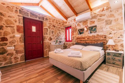 um quarto com uma cama e uma porta vermelha em Dreamy Stone House em Pesádha