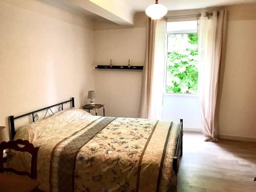 a bedroom with a bed in front of a window at Maison de vacances au cœur des Pyrénées in Eysus