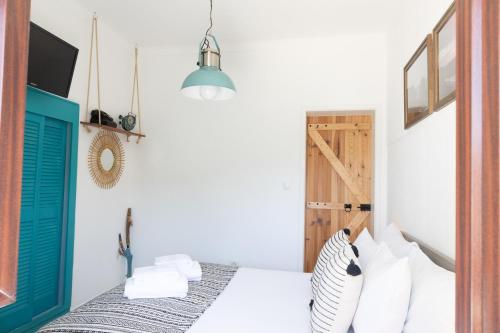 um quarto com uma cama e uma porta azul em Um Lugar ao Sol Beach House Azenhas do Mar em Sintra