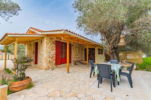 a patio with a table and chairs and a house at Dreamy Stone House in Pesádha