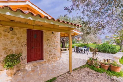 a stone house with a red door and a patio at Dreamy Stone House in Pesádha