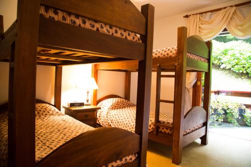 a bedroom with two bunk beds and a window at Apartamento para temporada no Alto do Capivari in Campos do Jordão