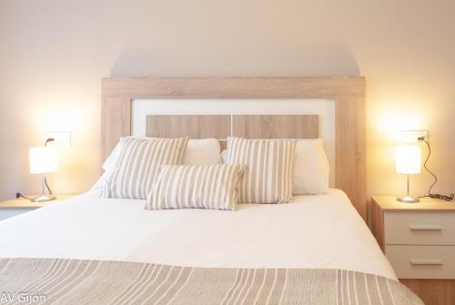 1 dormitorio con 1 cama blanca grande y 2 lámparas en AV Fernando Vela, en Oviedo