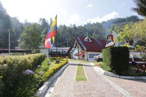 una bandera está volando delante de una casa en La Loma Del Sol, en Sogamoso