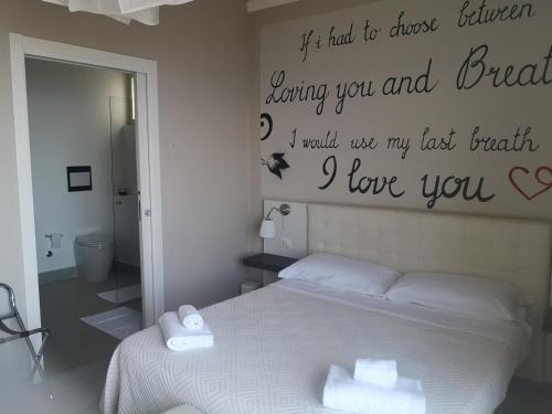 a bedroom with a bed with a sign on the wall at Athena Charming Rooms in Taormina