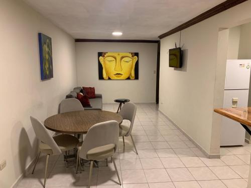 a dining room with a table and a yellow face on the wall at Departamento en Paseo Santa Lucía con Terraza D2 in Monterrey