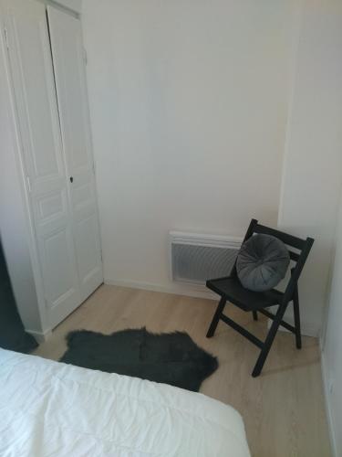 a bedroom with a chair with a pillow on it at La Terrasse in Mers-les-Bains