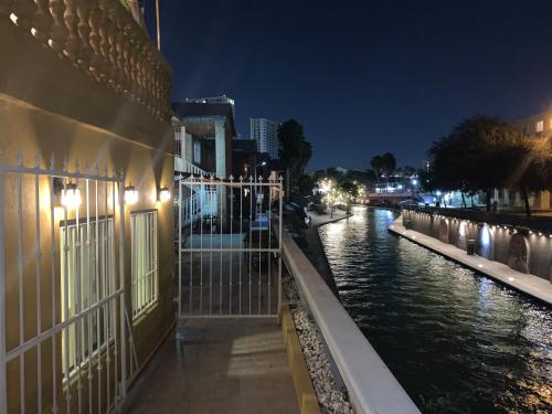 a building next to a river at night at Departamento en Paseo Santa Lucía con Terraza D2 in Monterrey