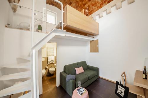 a living room with a green couch and a staircase at San Giovanni Vecchio - Residenza in Matera