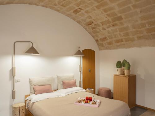 a bedroom with a bed with a tray of fruit on it at San Giovanni Vecchio - Residenza in Matera