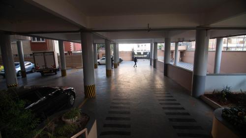 a person walking down a hallway in a building at Vasudev Heights Apartment near Yaya centre in Nairobi