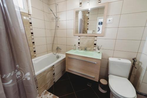 łazienka z wanną, toaletą i umywalką w obiekcie Apartament Alex w Sybinie