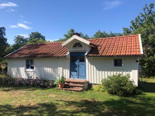 a small white house with an orange roof at Seaside Cottage Haga Park in Fröbygårda
