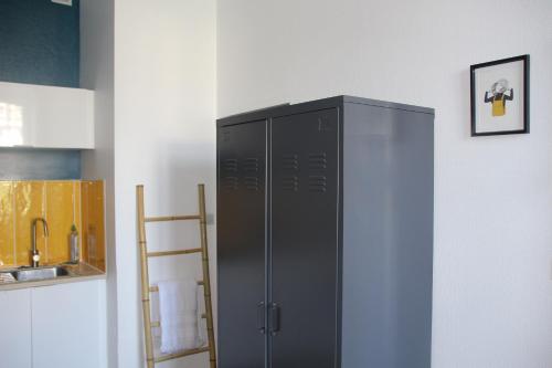 - un réfrigérateur noir dans le coin de la cuisine dans l'établissement Studio Le Petit Mousse Lannion, à Lannion