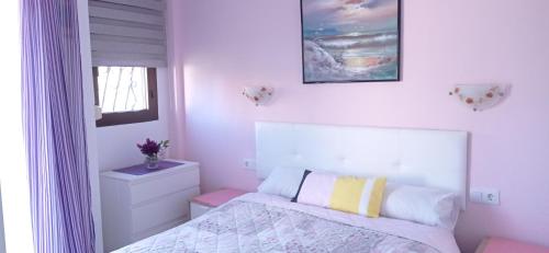 a white bedroom with a bed and a window at Apartamento Retiro in Denia