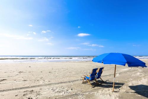a blue chair and an umbrella on the beach at Riverhouse in Johns Island