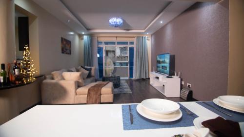 a living room with a couch and a television at Vasudev Heights Apartment near Yaya centre in Nairobi