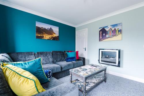 a living room with a couch and a blue wall at Relaxing 3 Bedroom Chester Home with garden in Broughton