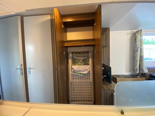 a mirror reflection of a room with a door at Coeur Des Sables in Saint-Julien-en-Born