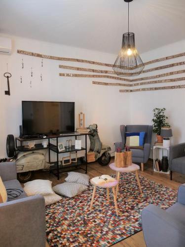 a living room with a tv and a couch and chairs at Casa da Livraria - Boutique da Cultura in Avis