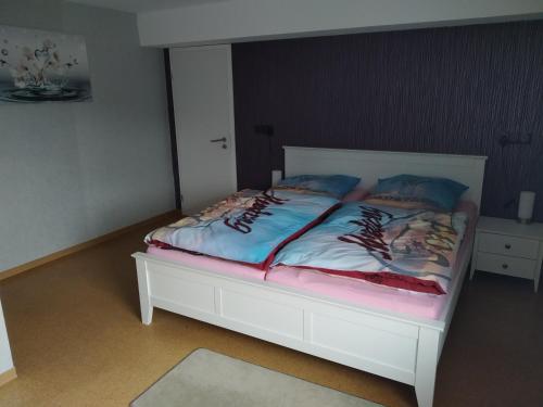 a bedroom with a bed with a white bed frame at Ferienwohnung Bussard in Patersberg