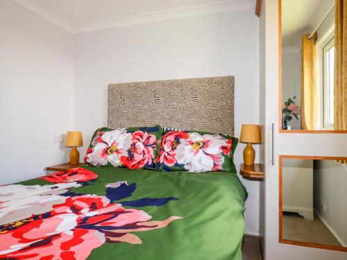 a bedroom with a bed with a colorful comforter at Lowena in Saint Day