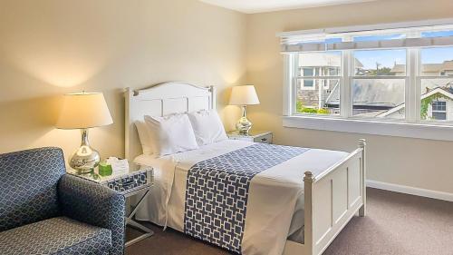 a bedroom with a bed and a chair and a window at Clegg's Hotel in Ocean Beach