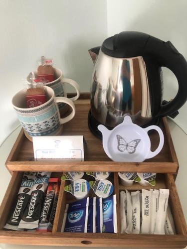 a wooden shelf with a tea kettle and tea packets at Drumcoo Guest House in Enniskillen