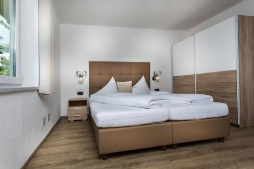 1 dormitorio con 1 cama grande con sábanas blancas en Appartement Leogang, en Leogang