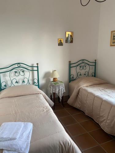 een slaapkamer met 2 bedden en een tafel met een lamp bij Agriturismo Martone in Rocca San Felice