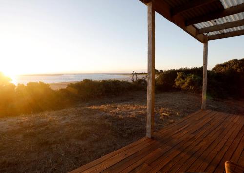 a wooden porch with a view of the ocean at The Inlet Stanley in Stanley