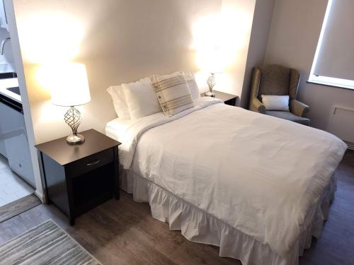 a bedroom with a bed with two lamps and a chair at Hotel Phillips in Bartlesville