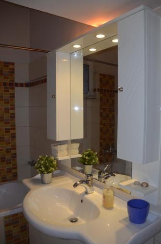 a bathroom with a sink and a large mirror at Family and Relaxing House in a Village in Rodotópion