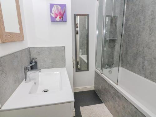 un bagno con lavandino e doccia di Watershed Cottage a Settle