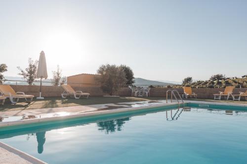 a swimming pool with blue water and chairs at Casa do Cruzeiro Quinta do Couto in Armamar