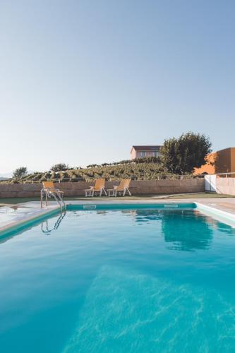 a large swimming pool with blue water at Casa do Cruzeiro Quinta do Couto in Armamar