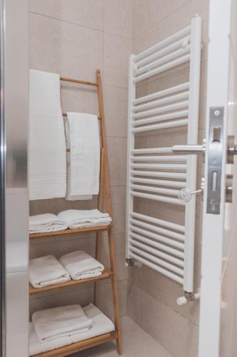 a bathroom with a rack of towels in a shower at Casa do Cruzeiro Quinta do Couto in Armamar